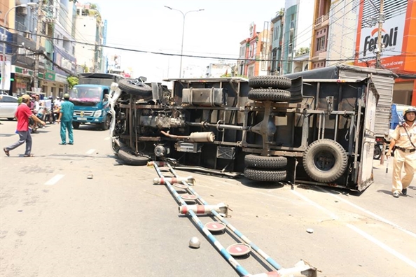 Xe tai cho bia lat ngang giua duong, 2 nguoi nguy kich