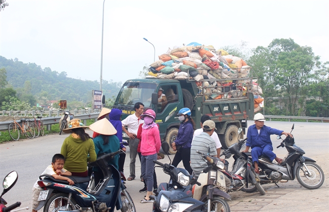 Buc xuc vi hoi thoi, nguoi dan keo nhau ra duong chan xe cho rac