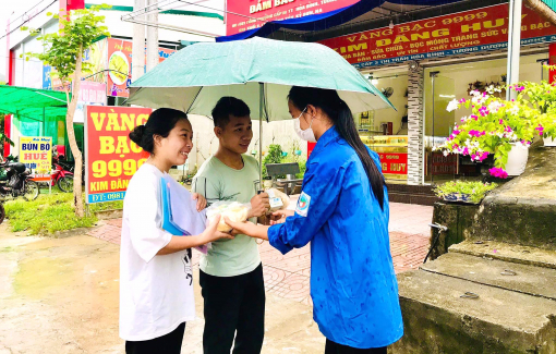 Túc trực ngay cổng trường để che ô, trao phần ăn sáng cho thí sinh