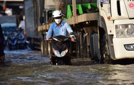 Người dân TPHCM bì bõm lội nước về nhà do triều cường