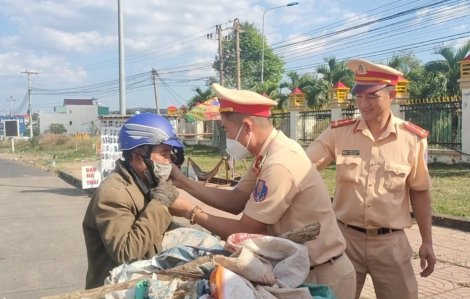 Cảnh sát giao thông phát nước, thức ăn cho người dân trên đường về quê ăn tết