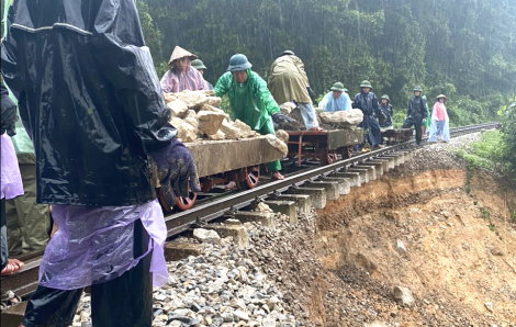 Công nhân dầm mưa chở đá gia cố đường sắt Bắc - Nam bị sạt lở