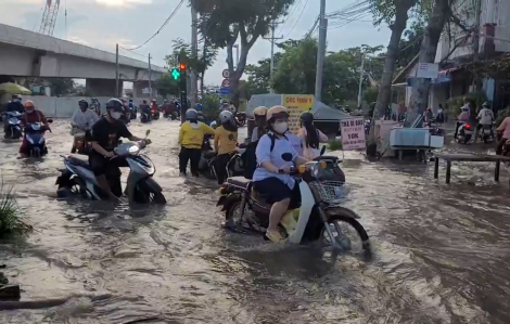 Người dân "vác xe" di chuyển giữa làn nước do triều cường