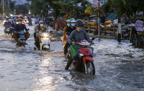 Người dân bì bõm dắt xe về nhà trong triều cường