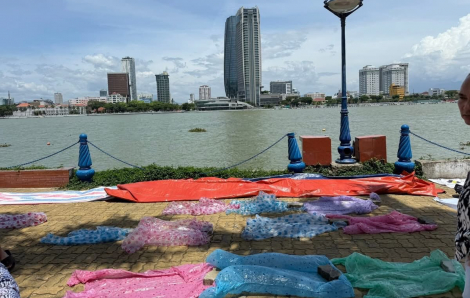 Nhiều người mang áo mưa trải kín vỉa hè giữa trưa nắng để xí chỗ xem pháo hoa