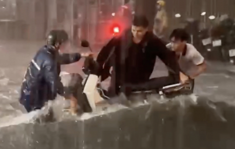 Người dân không ngại nguy hiểm, hỗ trợ nhau khi xe máy bị nước mưa cuốn trôi