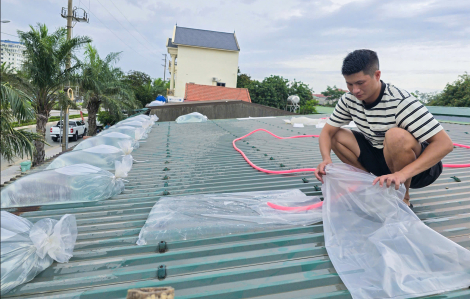 Người dân bơm nước lên mái nhà ứng phó bão số 5