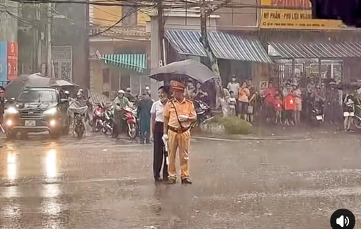Clip người dân che ô cho CSGT làm nhiệm vụ dưới cơn mưa lớn