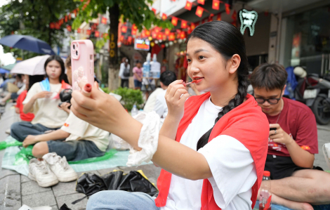 Nhiều bạn trẻ tranh thủ học bài, trang điểm trên vỉa hè chờ diễu binh, diễu hành