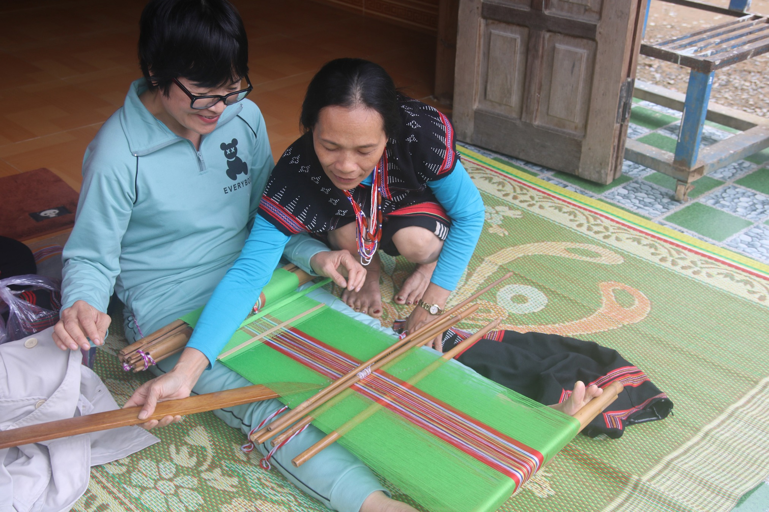 Người phụ nữ Cơ Tu của Hợp tác xã Nông nghiệp sinh thái và du lịch cộng đồng Hòa Bắc trở thành “thầy” dạy du khách dệt thổ cẩm.