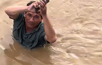 Người dân bì bõm giữa dòng nước lũ ngập đến gần cổ