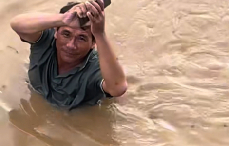 Người dân bì bõm giữa dòng nước lũ ngập đến gần cổ