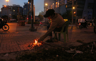 Nhiều người dân TPHCM mặc áo mưa, đốt lửa sưởi ấm để chống chọi cái lạnh 18 độ C