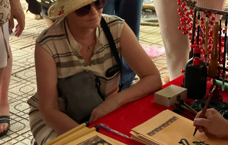 Khách Tây thích thú về miền Tây trải nghiệm gói bánh tét, xin chữ ông đồ