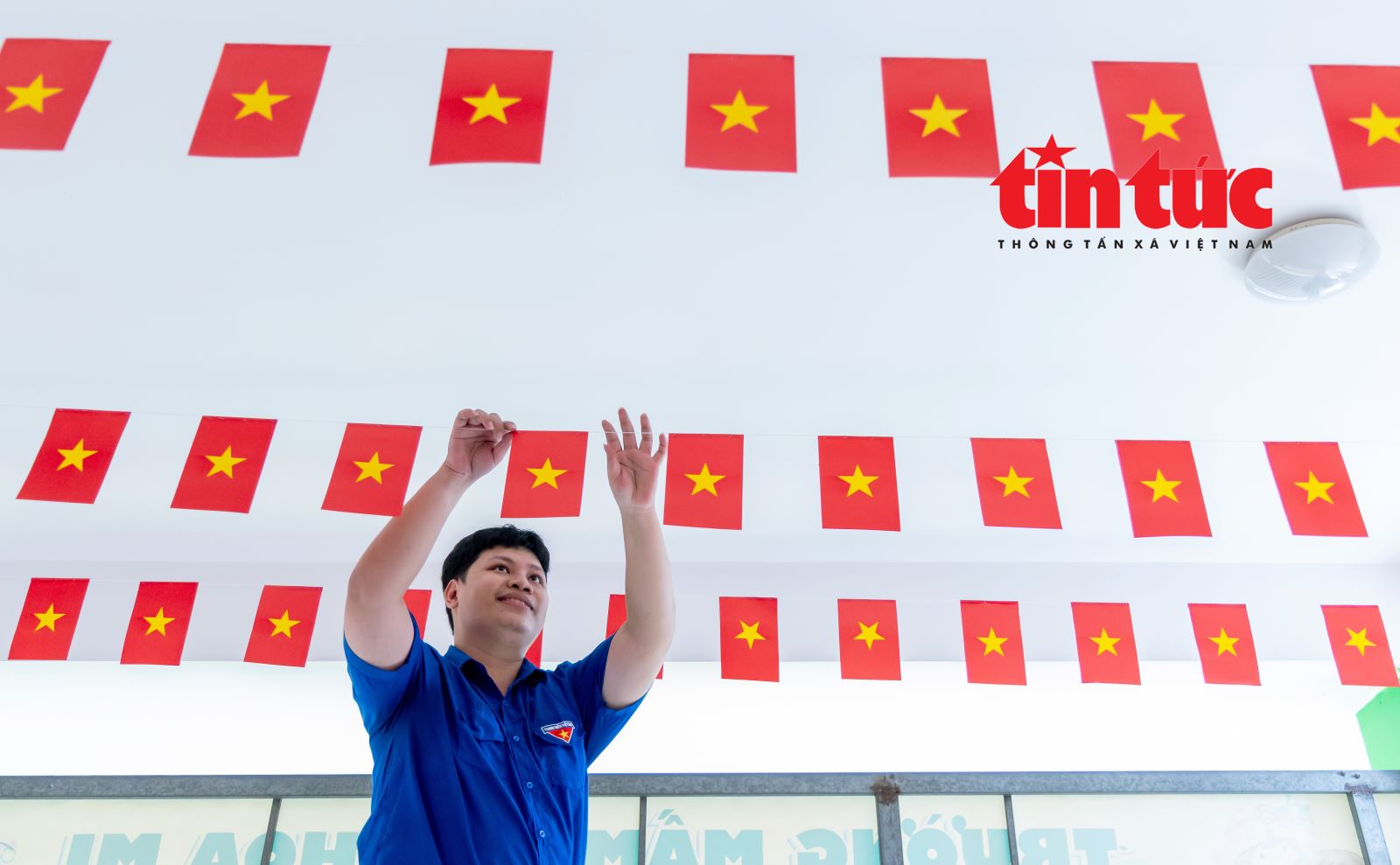 Đoàn viên thanh niên hỗ trợ trang trí cờ tại điểm bỏ phiếu số 20, phường An Nhơn (TP Hồ Chí Minh).