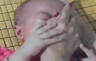 Công an triệu tập người phụ nữ dùng tay bịt miệng, mũi bé gái