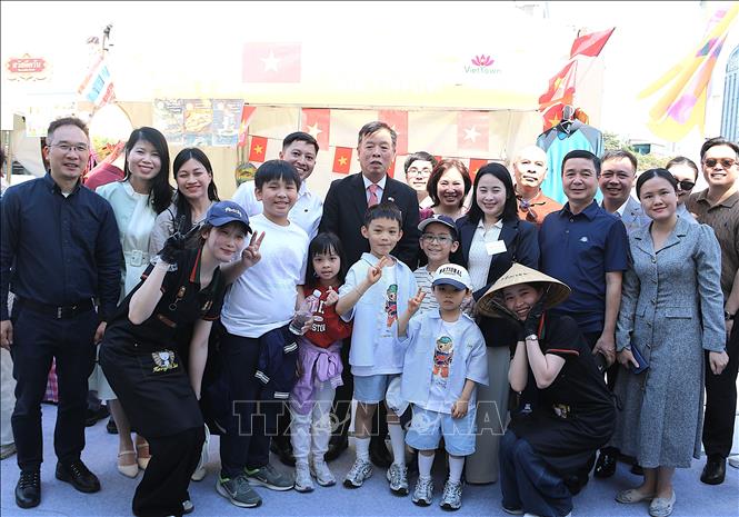 Đại sứ Vũ Hồ (giữa) cùng các thành viên ĐSQ Việt Nam trước gian hàng Việt Nam. Ảnh: Khánh Vân/PV TTXVN tại Hàn Quốc